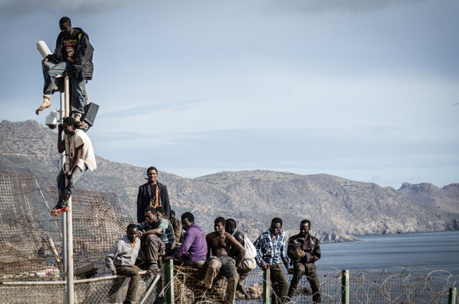 Des migrants tentent d'escalader la clôture à la frontière entre le Maroc et l'enclave espagnole de Melilla, le 3 avril 2014. © Photo Laura Tarraga Garrido / NurPhoto via AFP