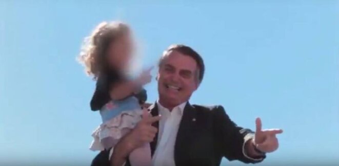 Le candidat Bolsonaro pousse une fillette à faire les "petites armes" avec ses doigts, en septembre 2018. © El Pais Brazil