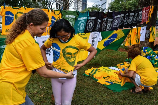 Une commerçante vend des tee-shirts verts et jaunes à l'effigie du candidat Bolsonaro, en 2018 au Brésil. © El Pais Brazil