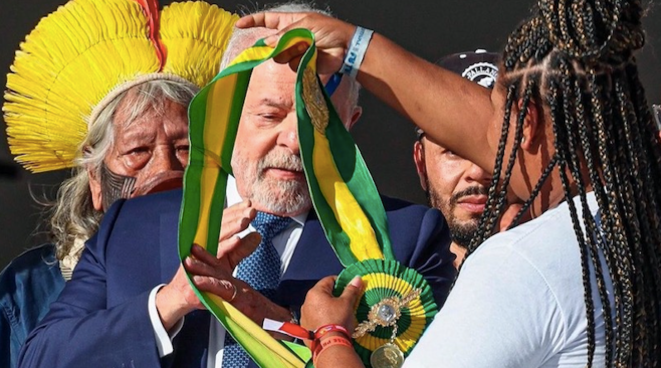 Aline Sousa, syndicaliste recycleuse de 33 ans issue de la société civile, remet l'écharpe présidentielle à Lula lors de la cérémonie d'investiture © Ricardo Stuckert
