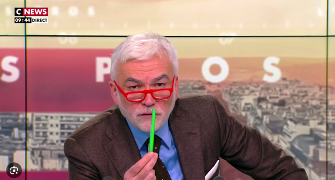 Un stylo vert et le journaliste Pascal Praud