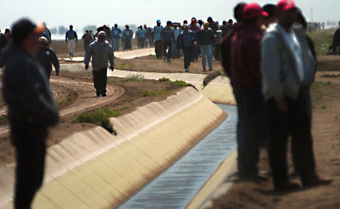 14 avril 2009 - Firebaugh, Californie, États-Unis- Sous l'égide de la California Latino Water Coalition, des milliers de travailleurs et travailleuses agricoles, d'exploitant·es et de responsables politiques de la région ont entamé mardi une marche de quatre jours pour attirer l'attention sur le manque d'eau allouée aux exploitations agricoles de la Central Valley. Ci-dessus, la marche franchit un fossé d'irrigation dans une ferme près de Firebaugh, dans l'ouest du comté de Fresno. © ZUMA Press, Inc. / Alamy Stock Photo.
