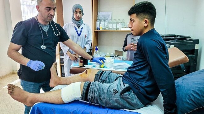 Ala Abou Alia, de 15 años, es atendido por el Dr. Iyad Naassan. Un colono israelí disparó al adolescente en ambas rodillas desde cerca cuando intentaba sacar a su primo de su casa, que fue atacada el 12 de abril. © Clothilde Mraffko para Mediapart