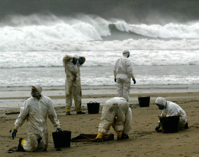 Des volontaires lavent une plage de Galice en décembre 2012, après la marée noire du Prestige. © Marcelo del Pozo / Reuters. Des volontaires lavent une plage de Galice en décembre 2012, après la marée noire du Prestige. © Marcelo del Pozo / Reuters.