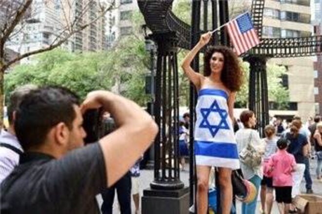 Une femme vêtue seulement d'un drapeau israélien lors d'une manifestation devant l'Organisation des Nations Unies 28/07/14 NY © AFP / Stan Honda Une femme vêtue seulement d'un drapeau israélien lors d'une manifestation devant l'Organisation des Nations Unies 28/07/14 NY © AFP / Stan Honda