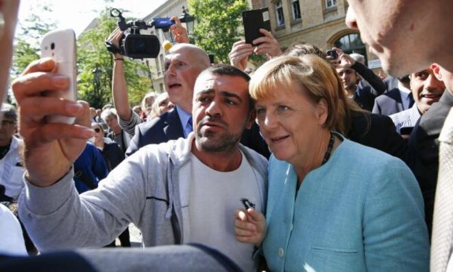 Angela Merkel, le 10 septembre, fait un selfie avec un réfugié lors de la visite d'un centre d'accueil à Berlin. © Reuters Angela Merkel, le 10 septembre, fait un selfie avec un réfugié lors de la visite d'un centre d'accueil à Berlin. © Reuters