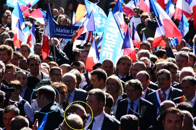 Muni d'une oreillette, Axel Loustau (cercle bleu) se situe devant les Le Pen, tout comme Daniel Mack (cercle jaune). © Reflexes