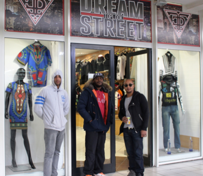 Kevin (au centre) devant sa boutique dans le centre commercial Kevin (au centre) devant sa boutique dans le centre commercial