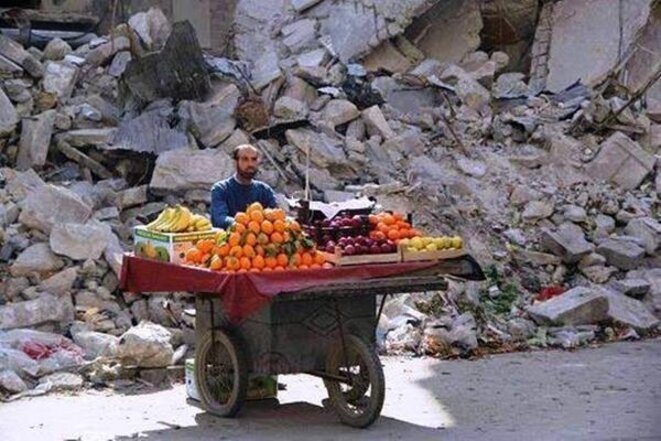 Vendeur de fruit devant un immeuble détruit Vendeur de fruit devant un immeuble détruit