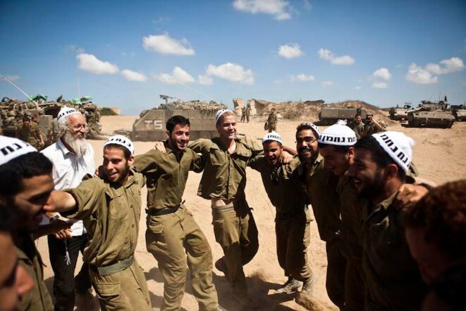 Des soldats israéliens dansent avec les membres d'une secte orthodoxe, devanat Gaza. Juillet 2014. © Nir Elias/Reuters Des soldats israéliens dansent avec les membres d'une secte orthodoxe, devanat Gaza. Juillet 2014. © Nir Elias/Reuters