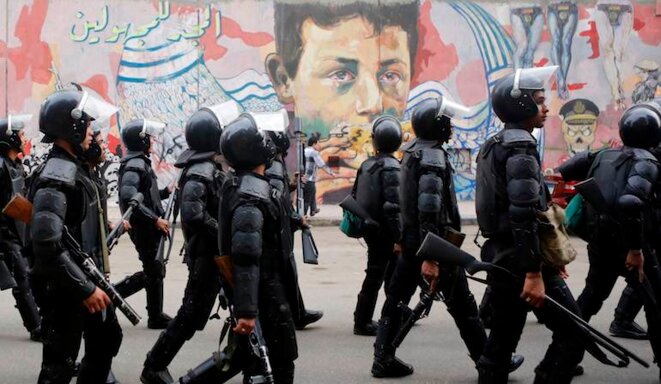 La police égyptienne devant des graffitis anti-militaires, le 19 novembre 2014. © Amr Dalsh/Reuters La police égyptienne devant des graffitis anti-militaires, le 19 novembre 2014. © Amr Dalsh/Reuters