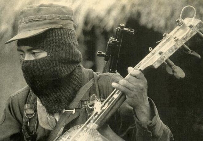 Un zapatiste cagoulé jouant du Guitarrón Un zapatiste cagoulé jouant du Guitarrón